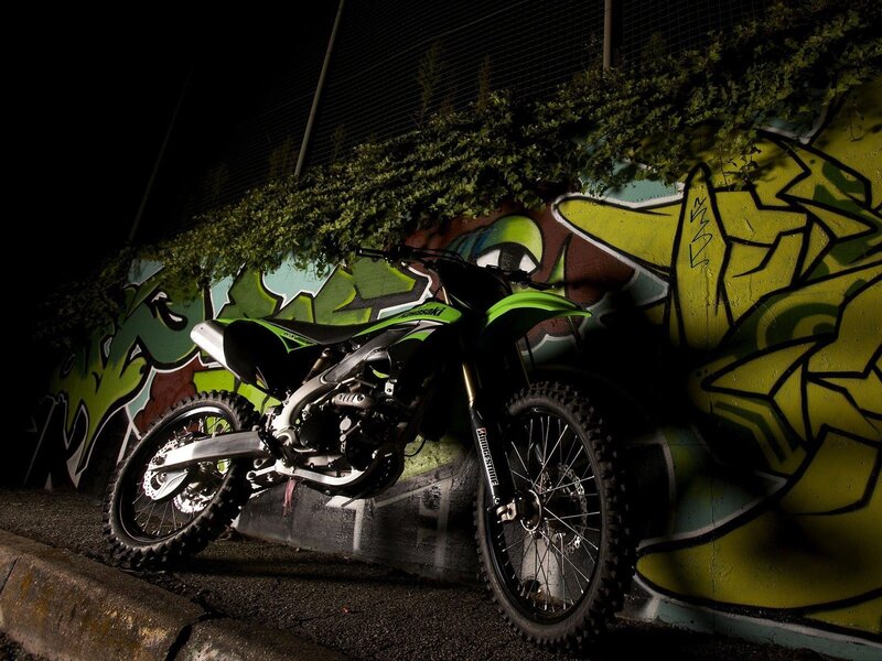 Green motorcycle against graffiti wall