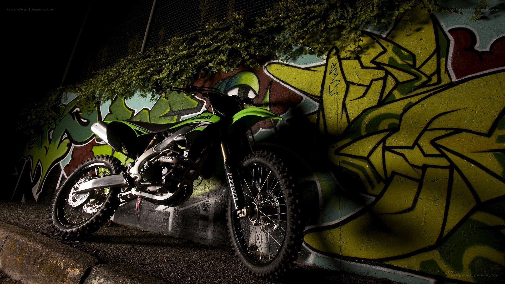 Green motorcycle against graffiti wall