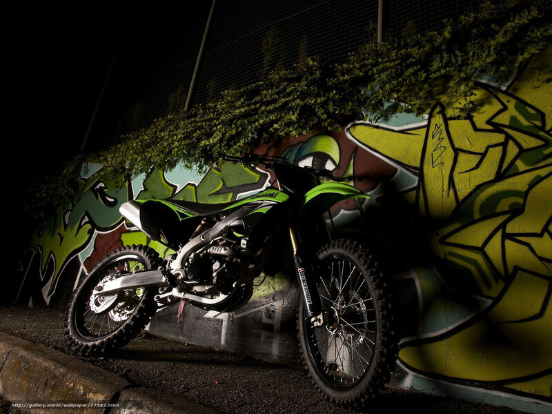 Green motorcycle against graffiti wall