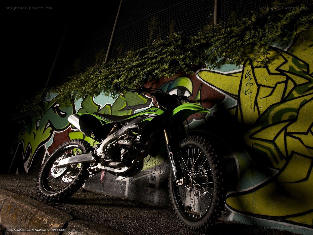 Green motorcycle against graffiti wall