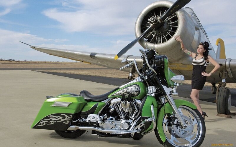 Green motorcycle and vintage plane
