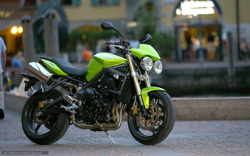 green motorcycle on cobblestone