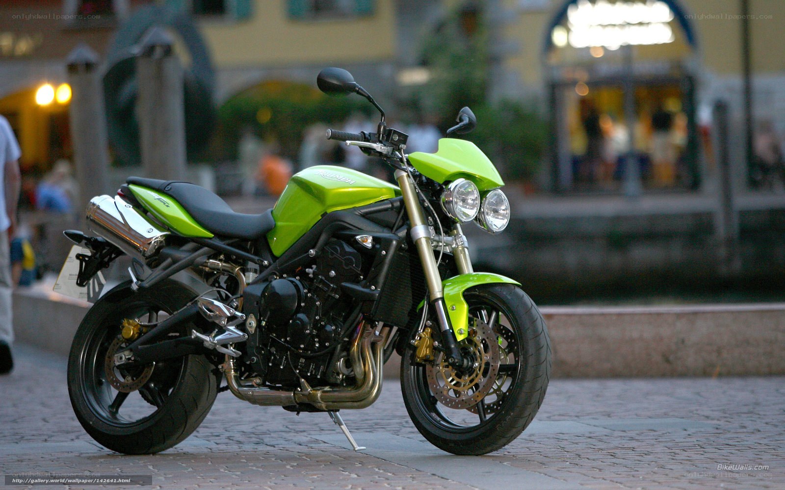 green motorcycle on cobblestone