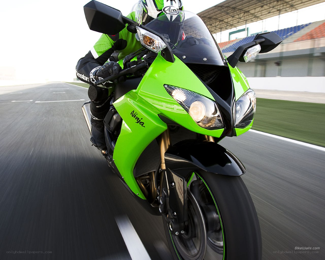 green motorcycle on racetrack
