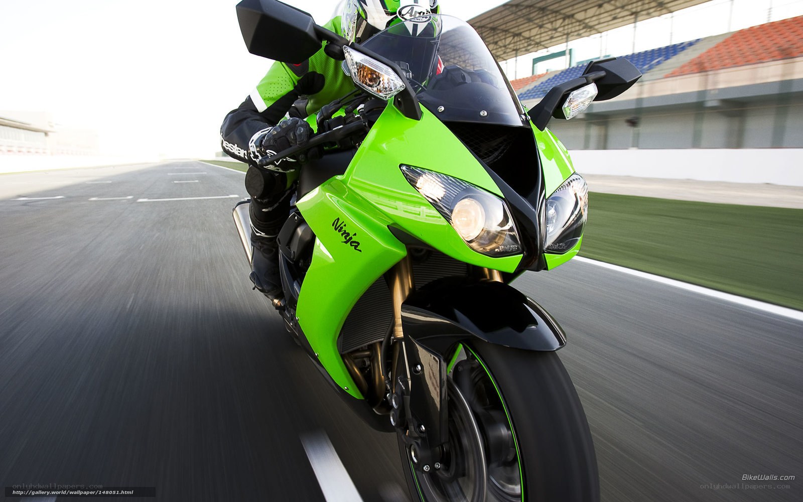 green motorcycle on racetrack