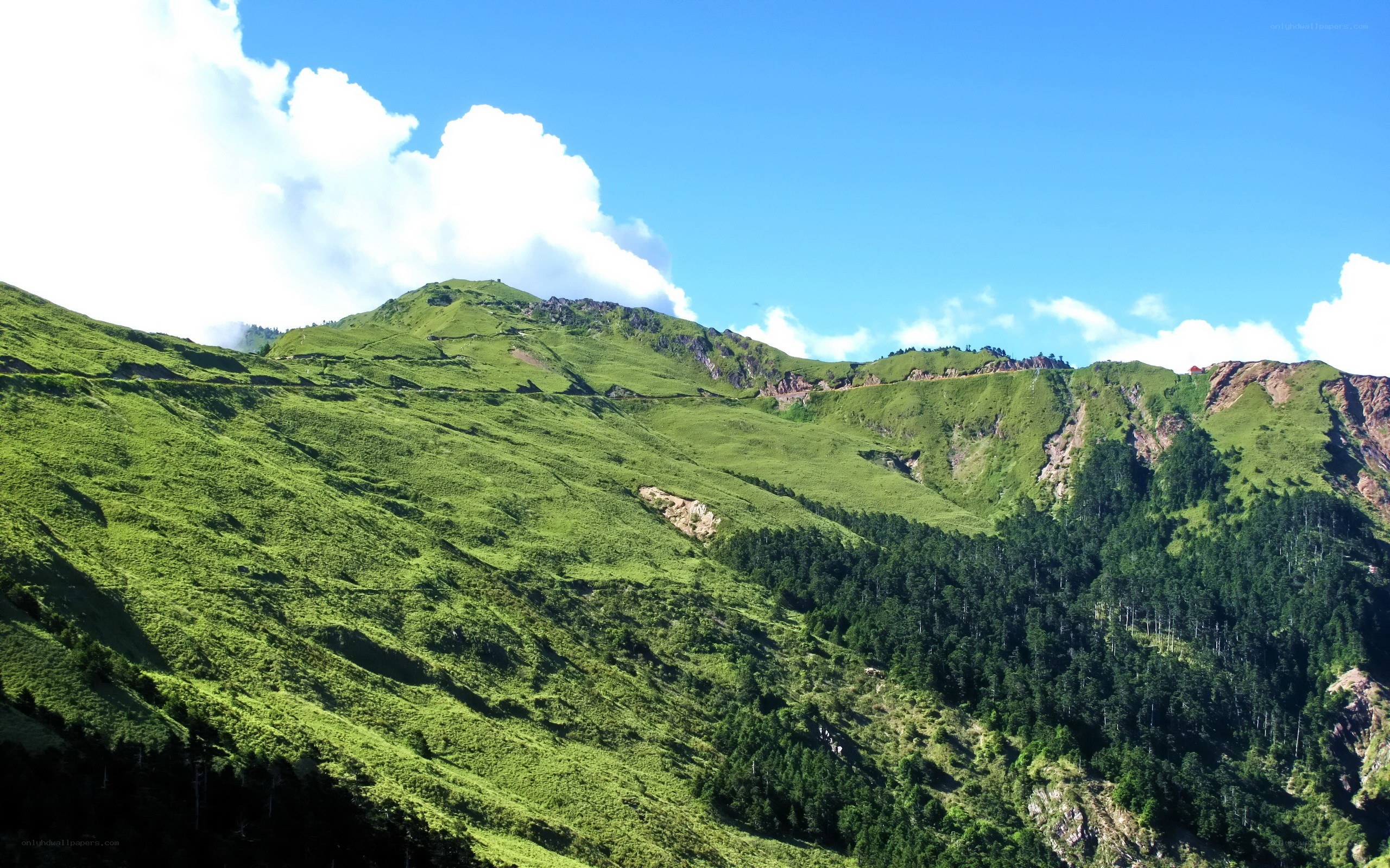 Green mountain landscape under blue sky
