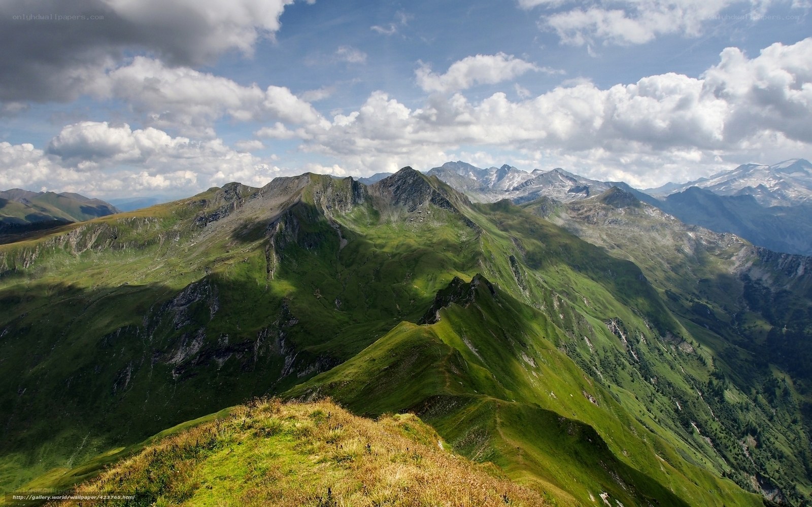 Green mountain peaks under cloudy sky