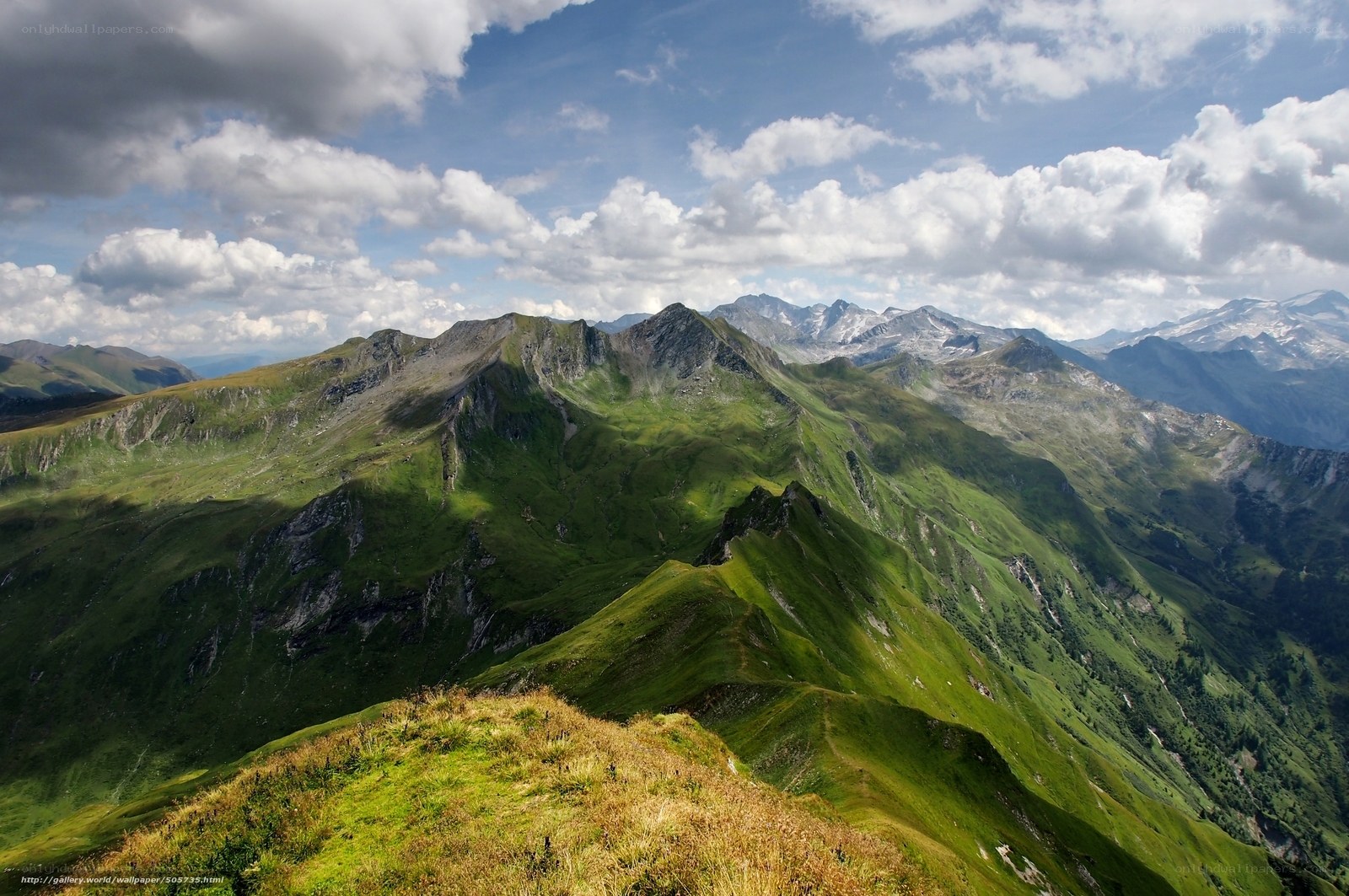 Green mountain peaks under cloudy sky