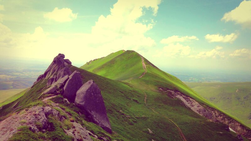 Green mountain ridge under cloudy sky