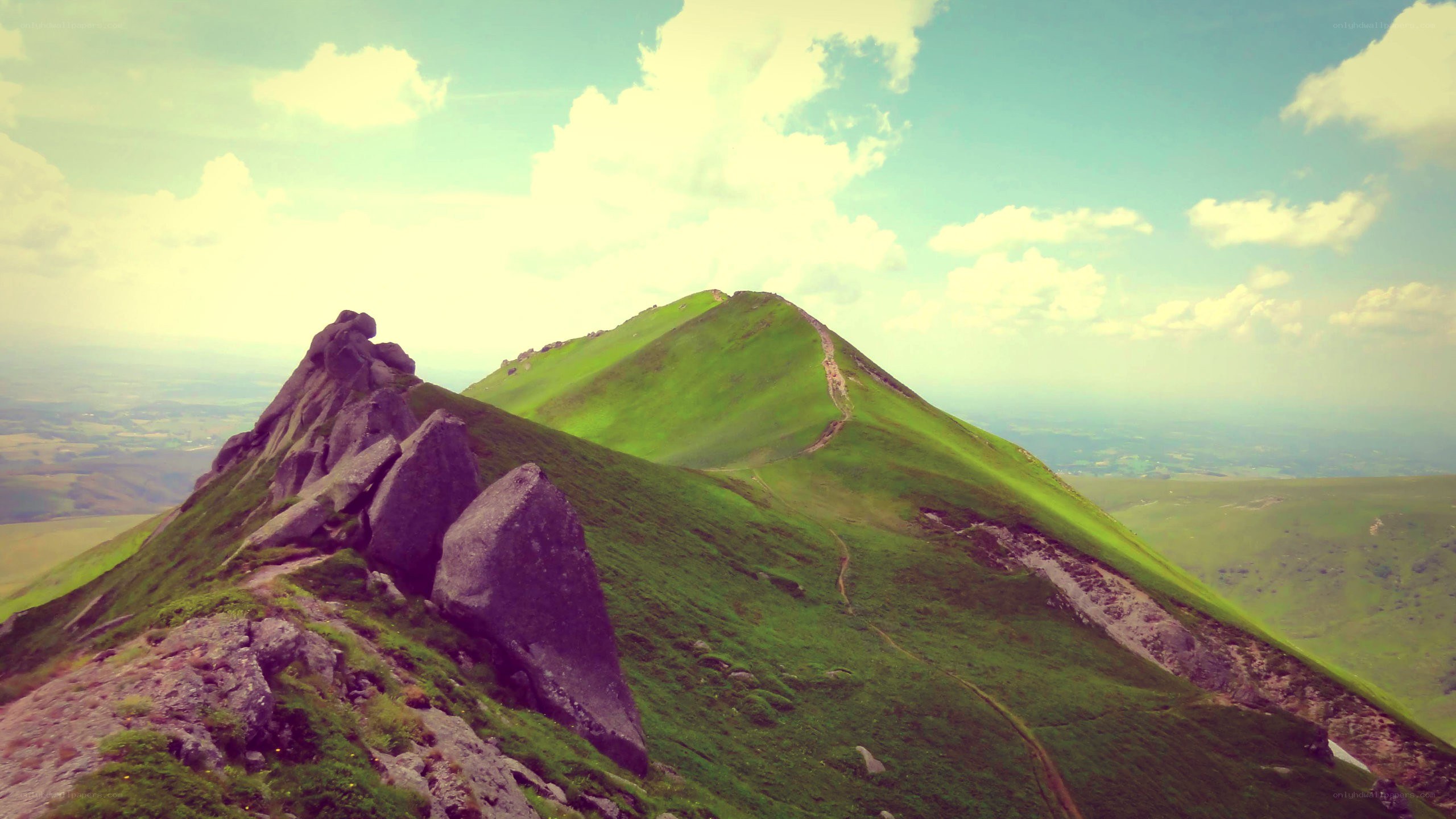 Green mountain ridge under cloudy sky