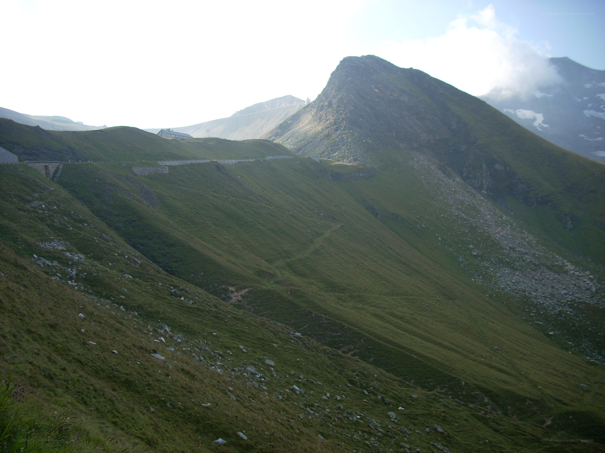 Green mountain slopes with stone wall