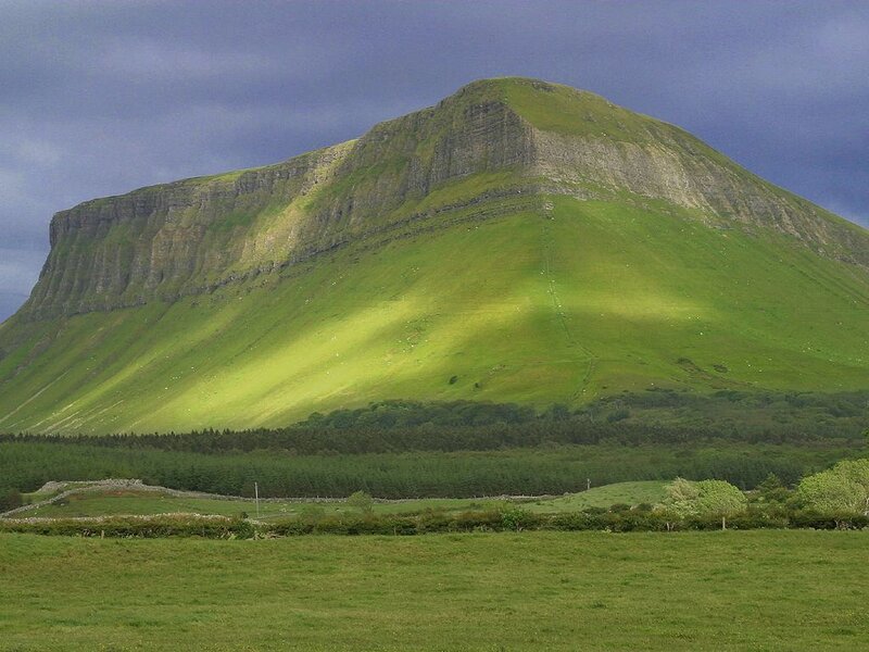Green mountain under cloudy sky