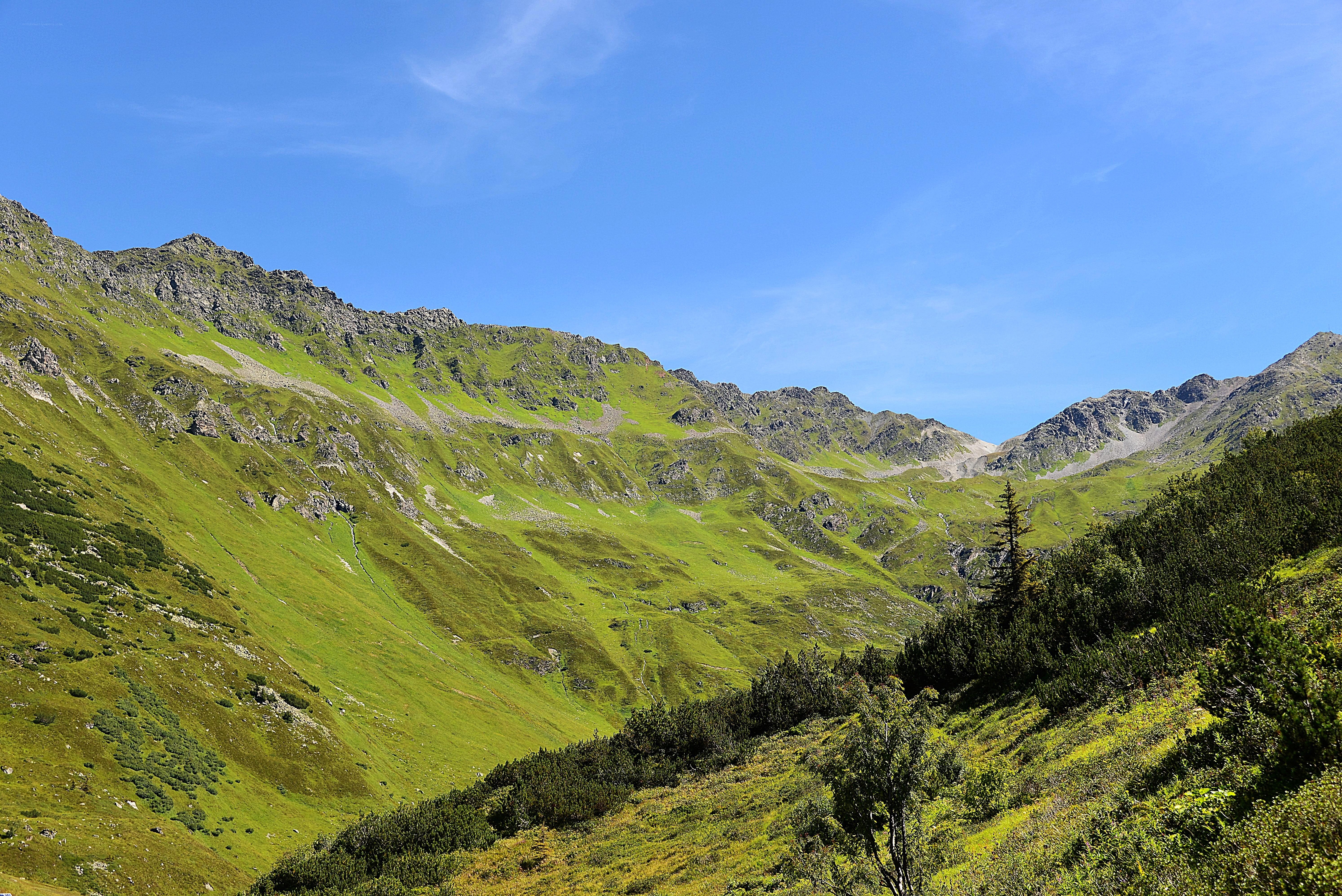 Green mountain valley under blue sky