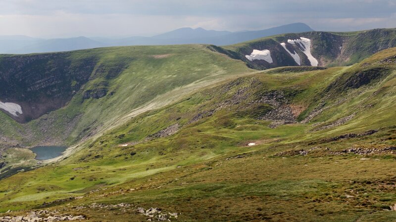 green mountain valley with snow patches