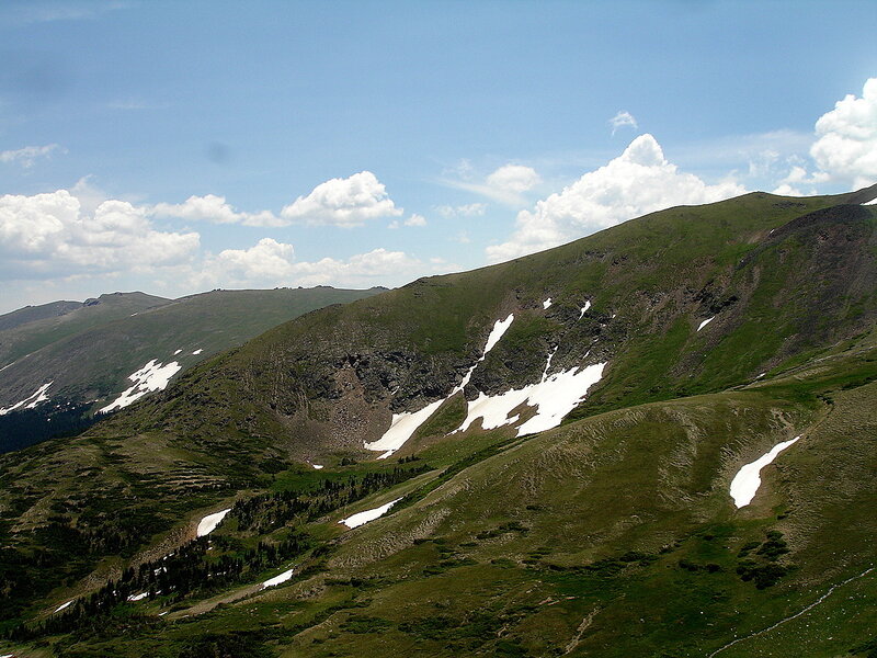 green mountain with snow patches