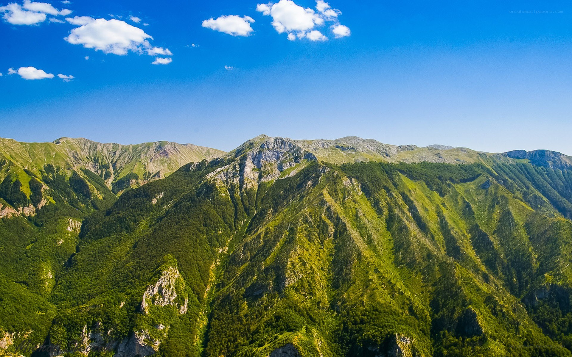 Green mountains under blue sky