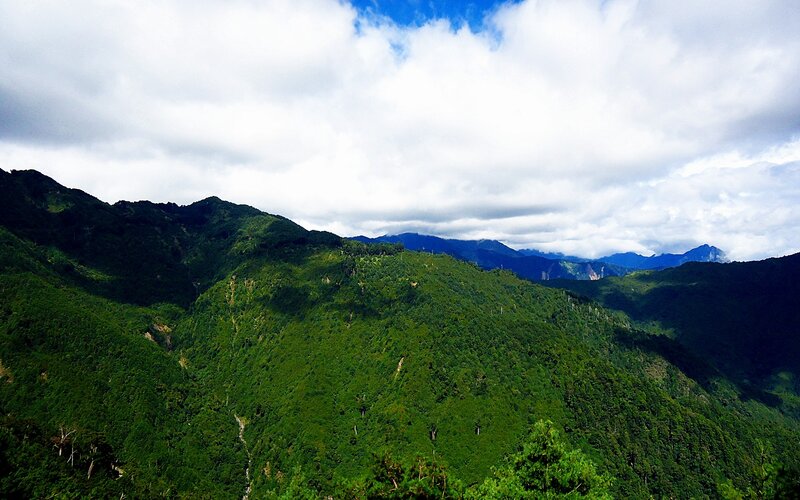 Green mountains under cloudy sky