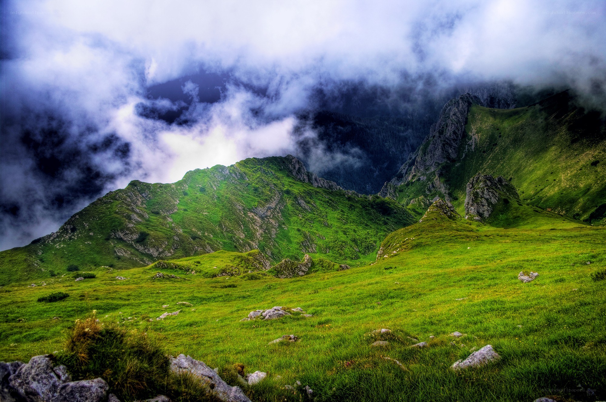 Green mountains under cloudy sky