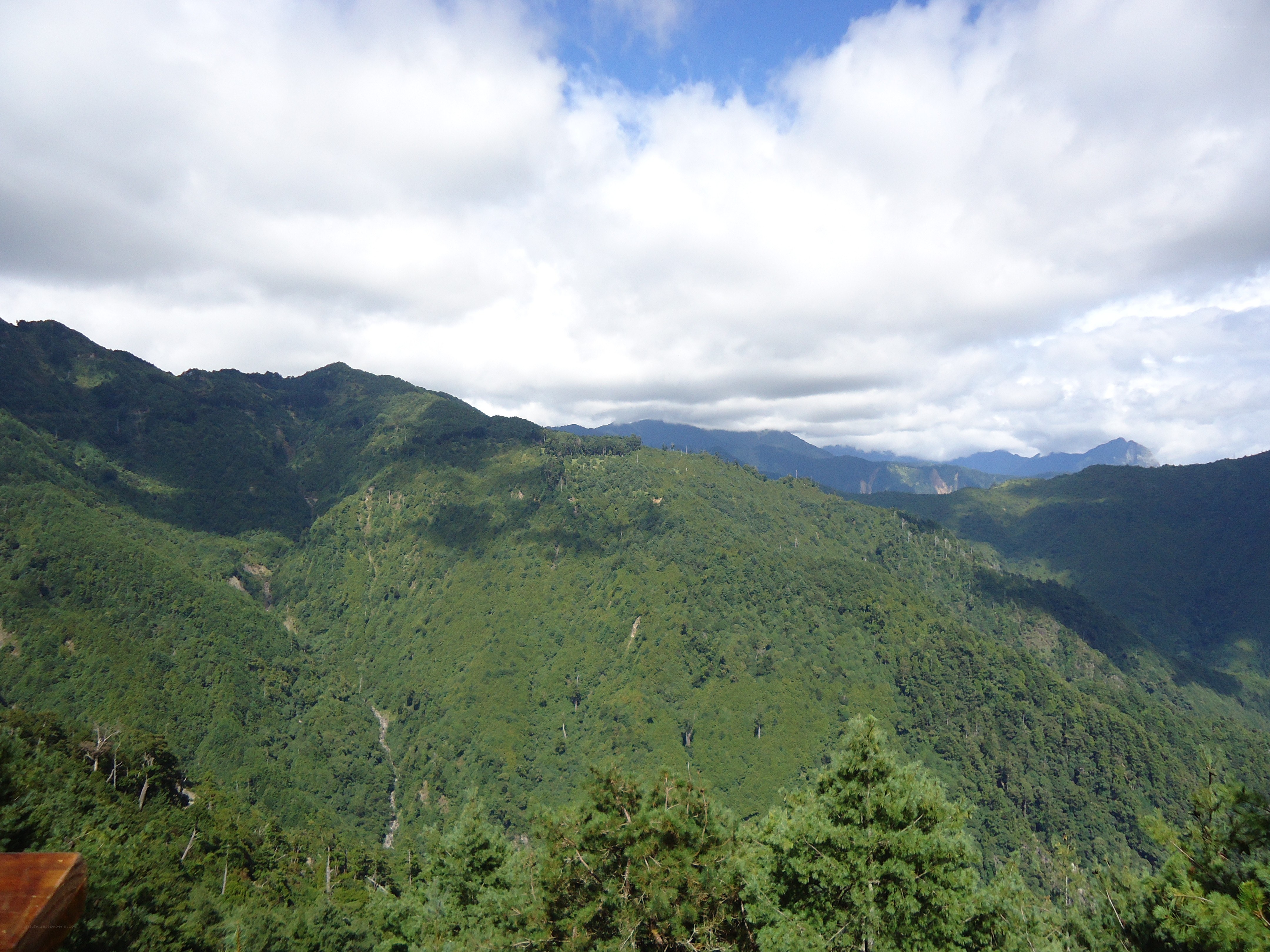 Green mountains under cloudy sky