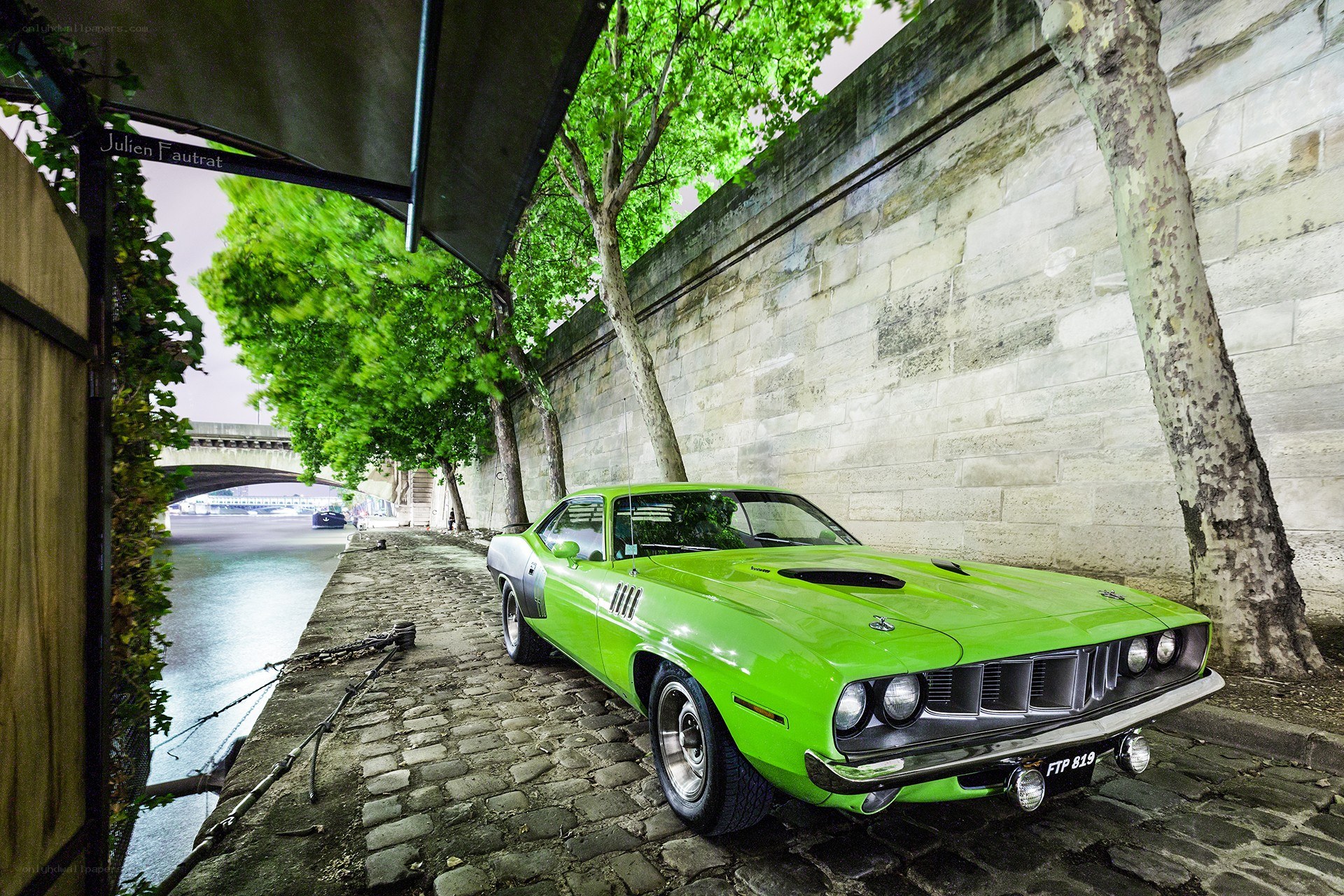 Green muscle car on cobblestone