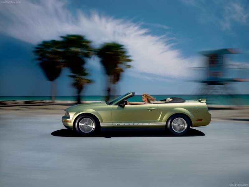 Green Mustang convertible on beach road