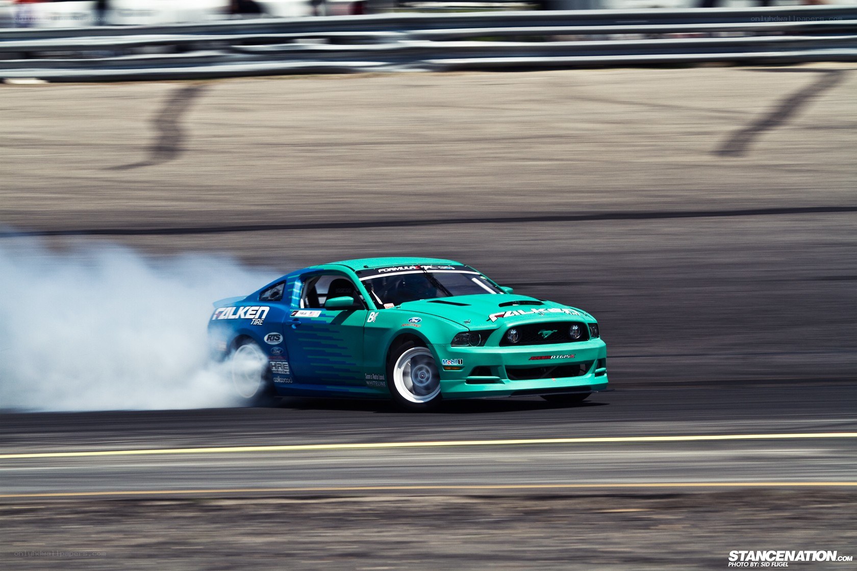 Green Mustang drifting on track