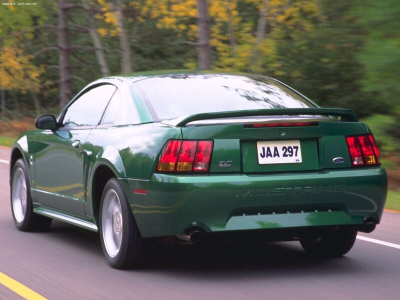 green mustang driving on road