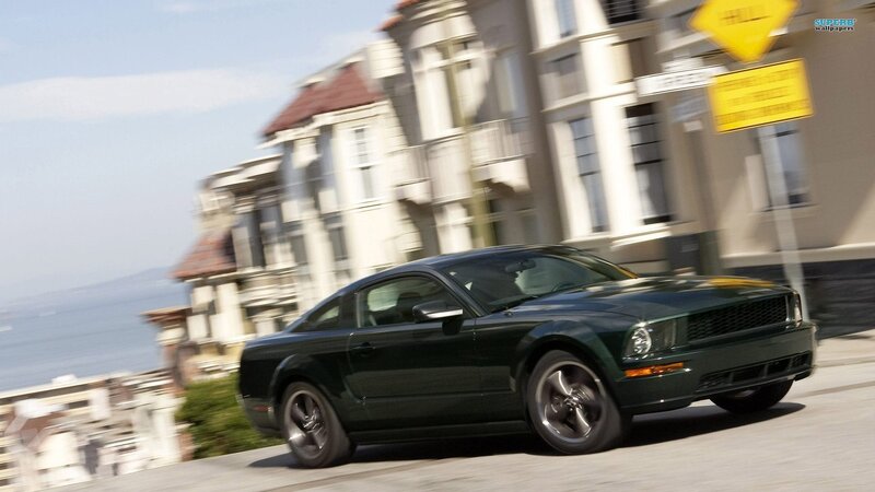 green mustang driving on street