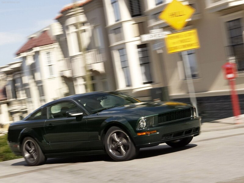 green mustang driving on street