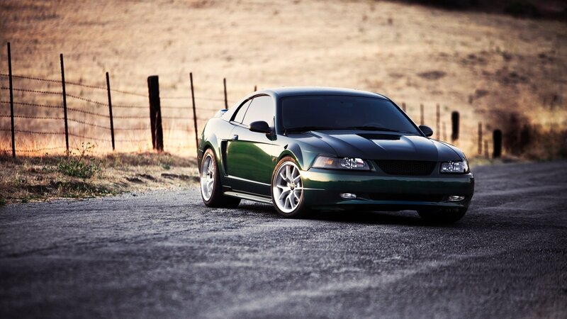Green Mustang on a rural road