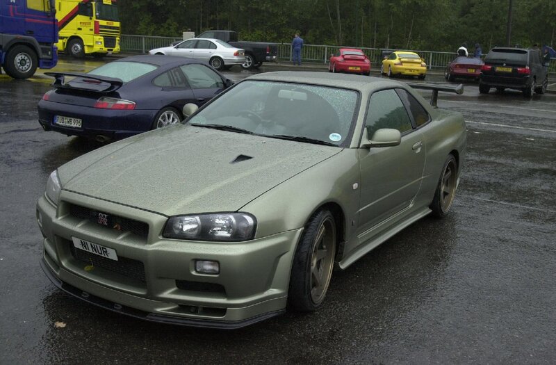 Green Nissan GT-R on wet pavement