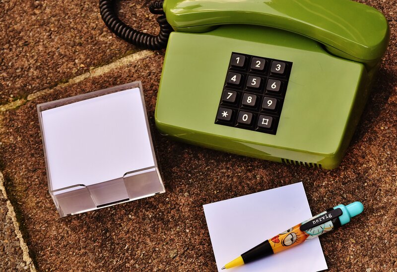 Green phone with notepad and pen