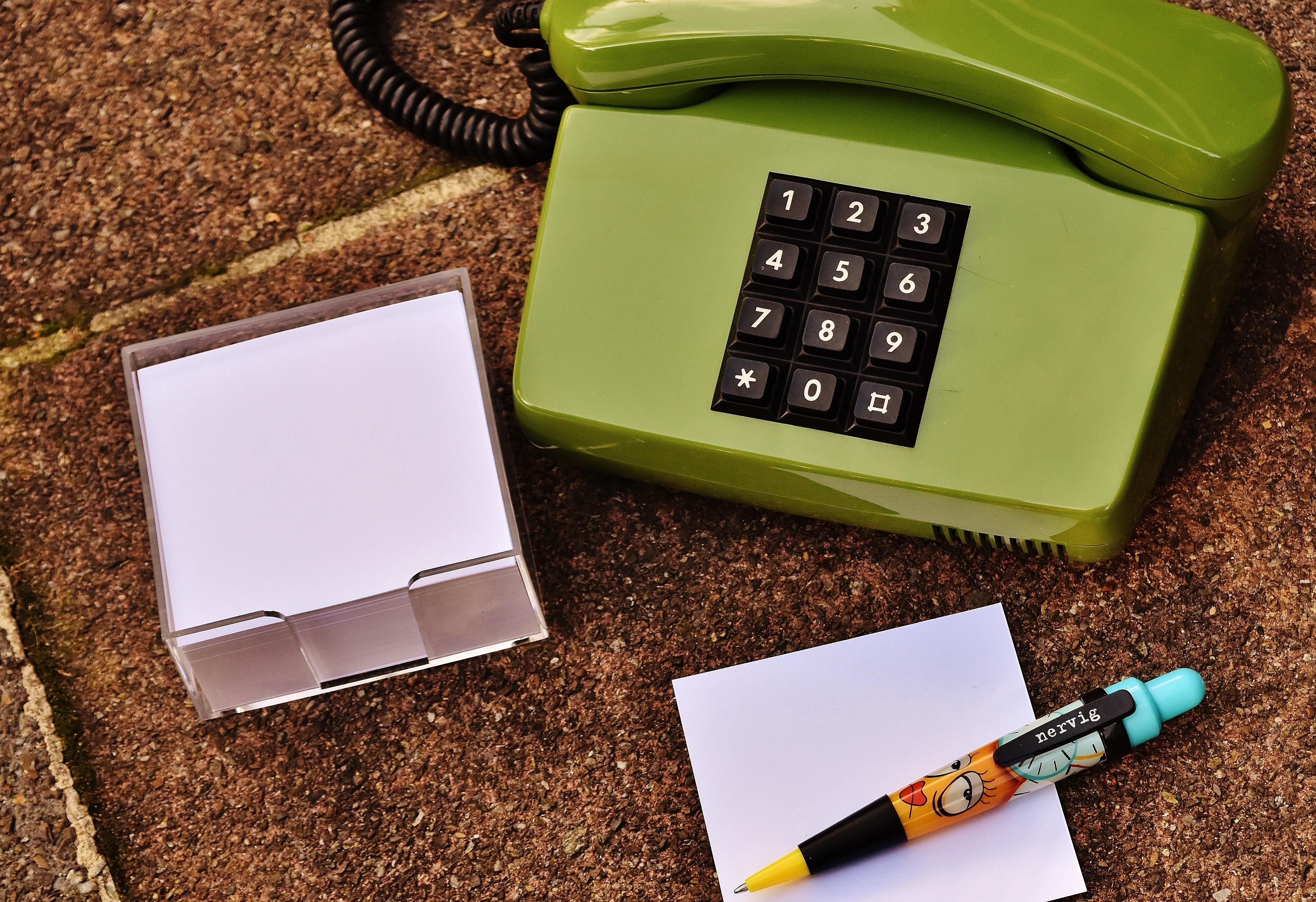 Green phone with notepad and pen