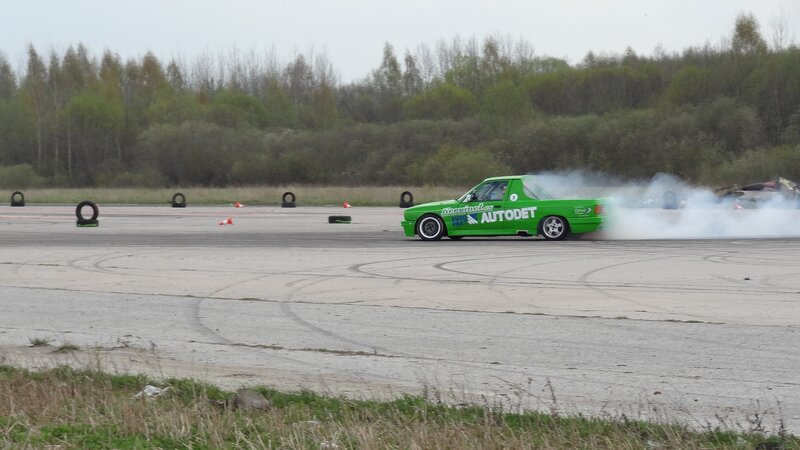 Green pickup drifting on track