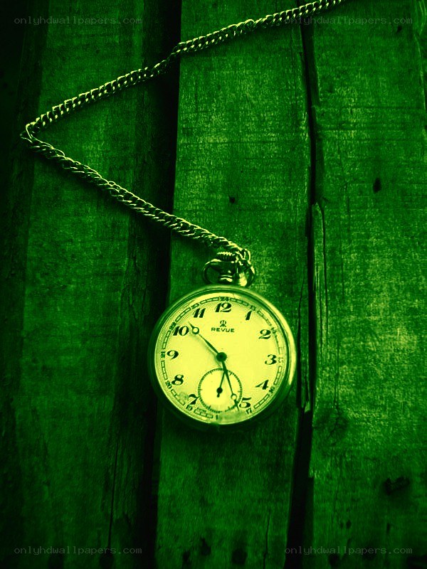 green pocket watch on wood