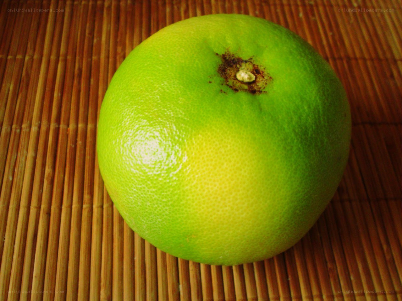 green pomelo on bamboo mat