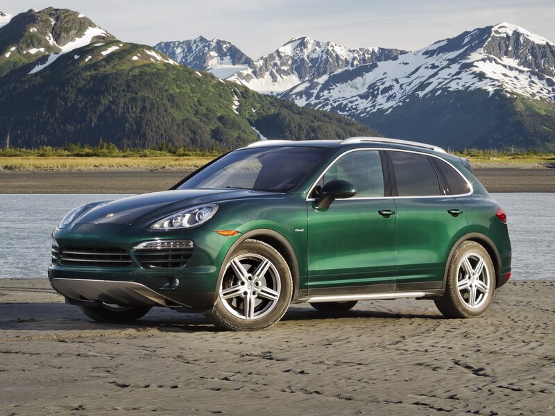 Green Porsche Cayenne in mountain landscape