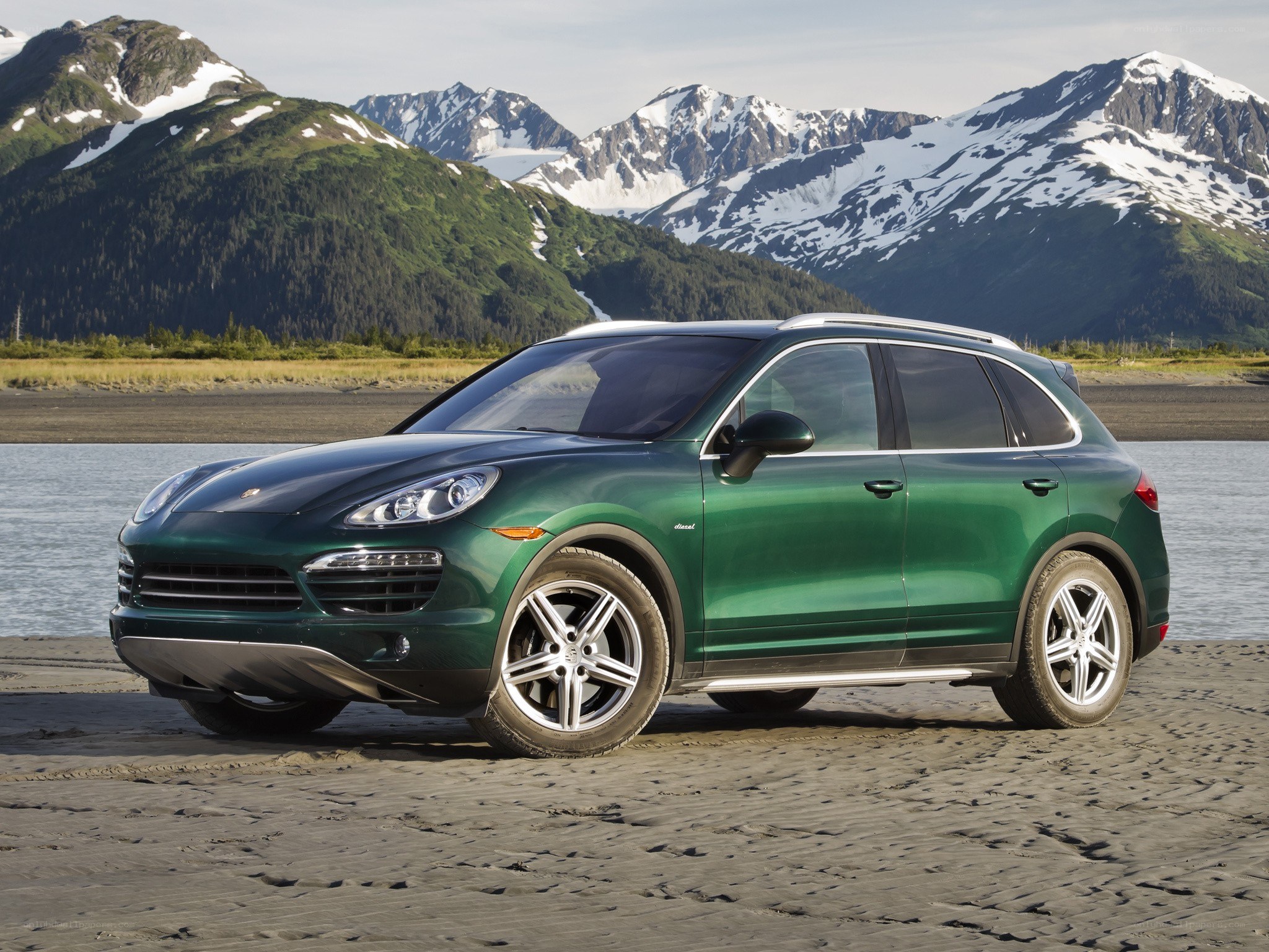 Green Porsche Cayenne in mountain landscape
