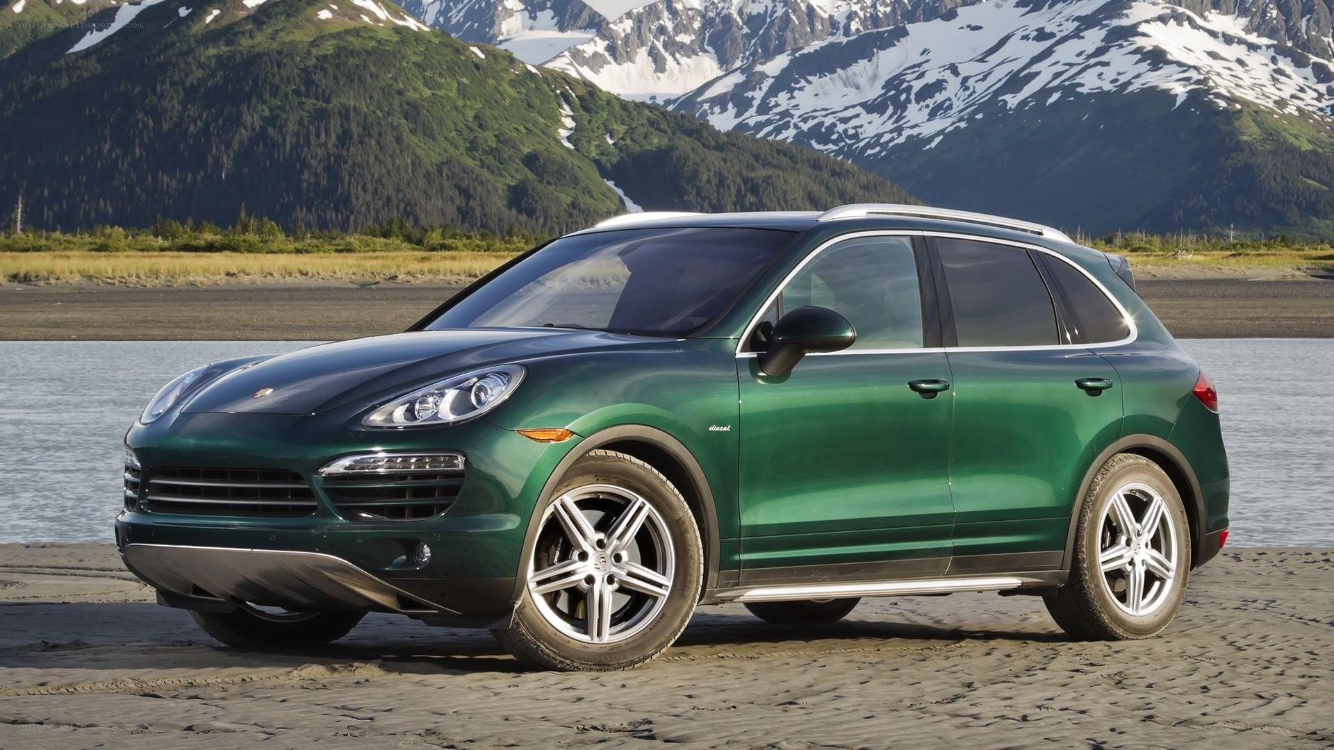 Green Porsche Cayenne on beach