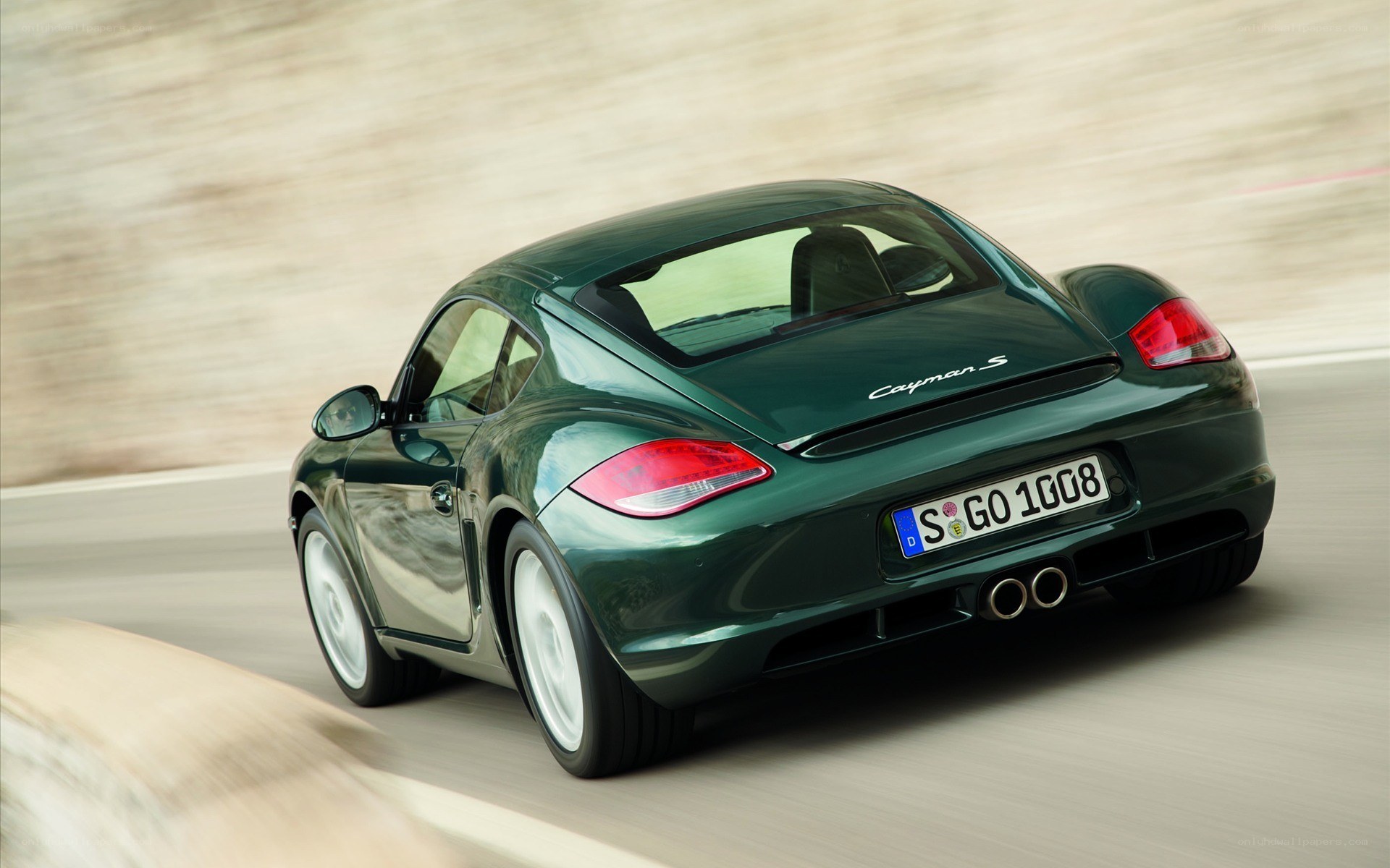 Green Porsche Cayman S in motion