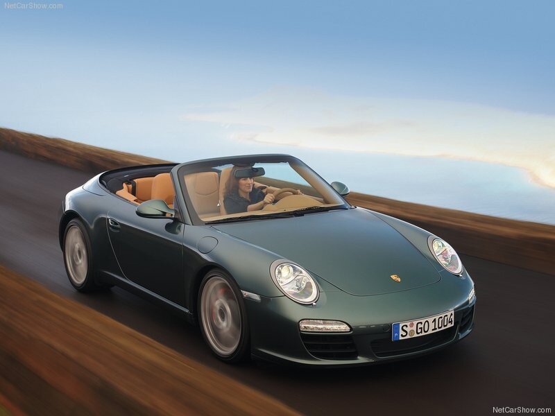 Green Porsche convertible on coastal road