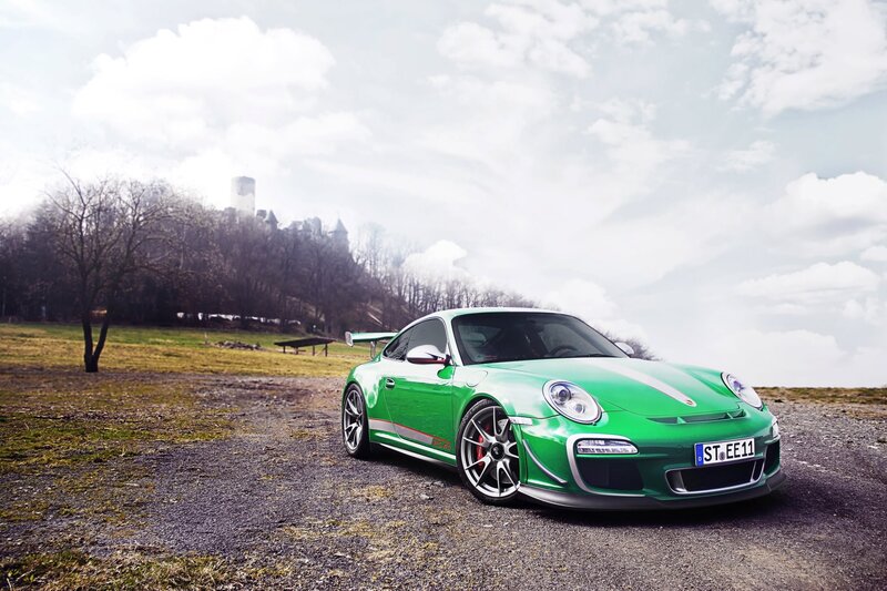 Green Porsche on a gravel road