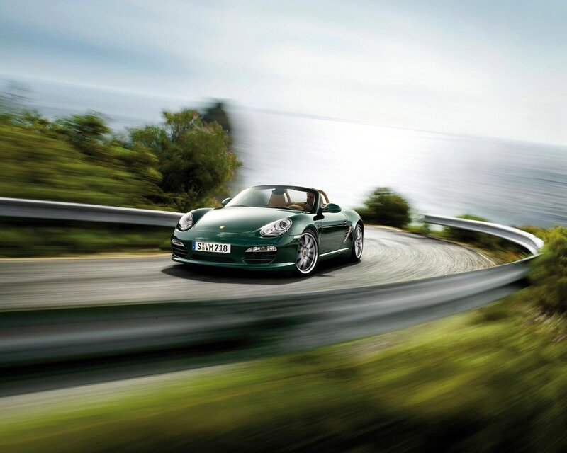 Green Porsche on coastal road