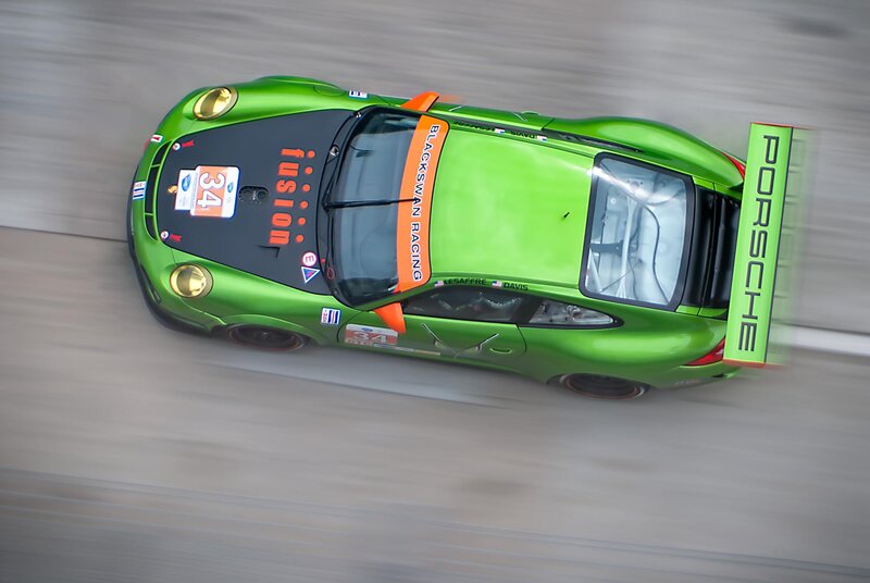 Green Porsche race car in motion