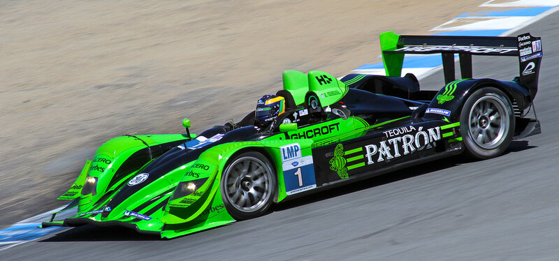 Green Race Car on Track — Dynamic, Afternoon, Photograph, Driver, Race Track, Safety Barrier