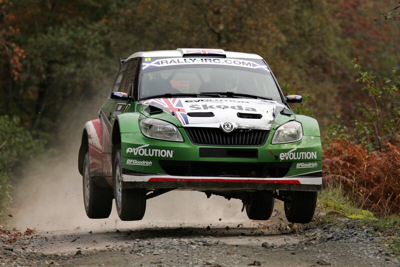 Green rally car in mid-air jump