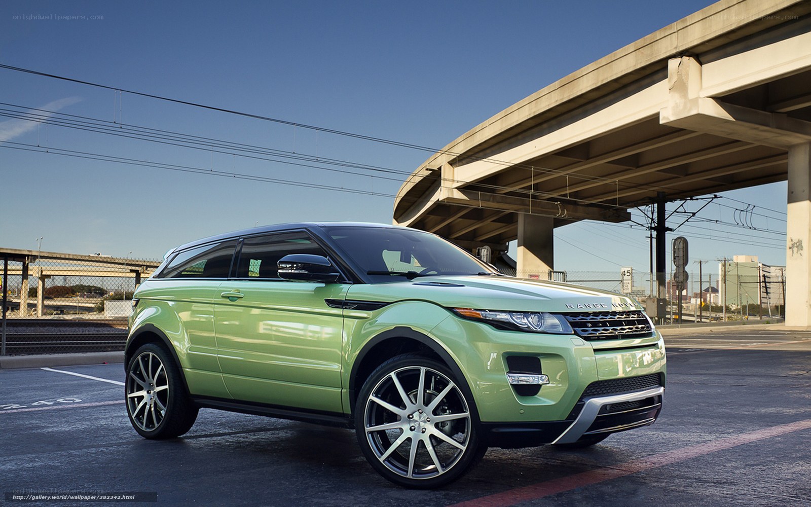 Green Range Rover parked under overpass