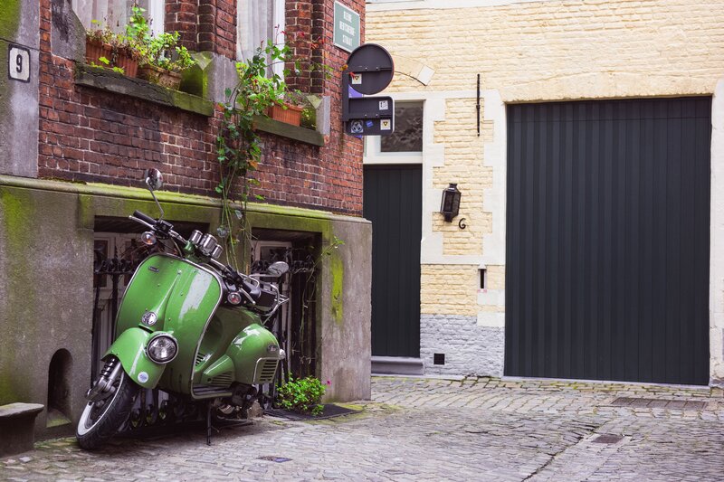 Green scooter in a cobblestone alley