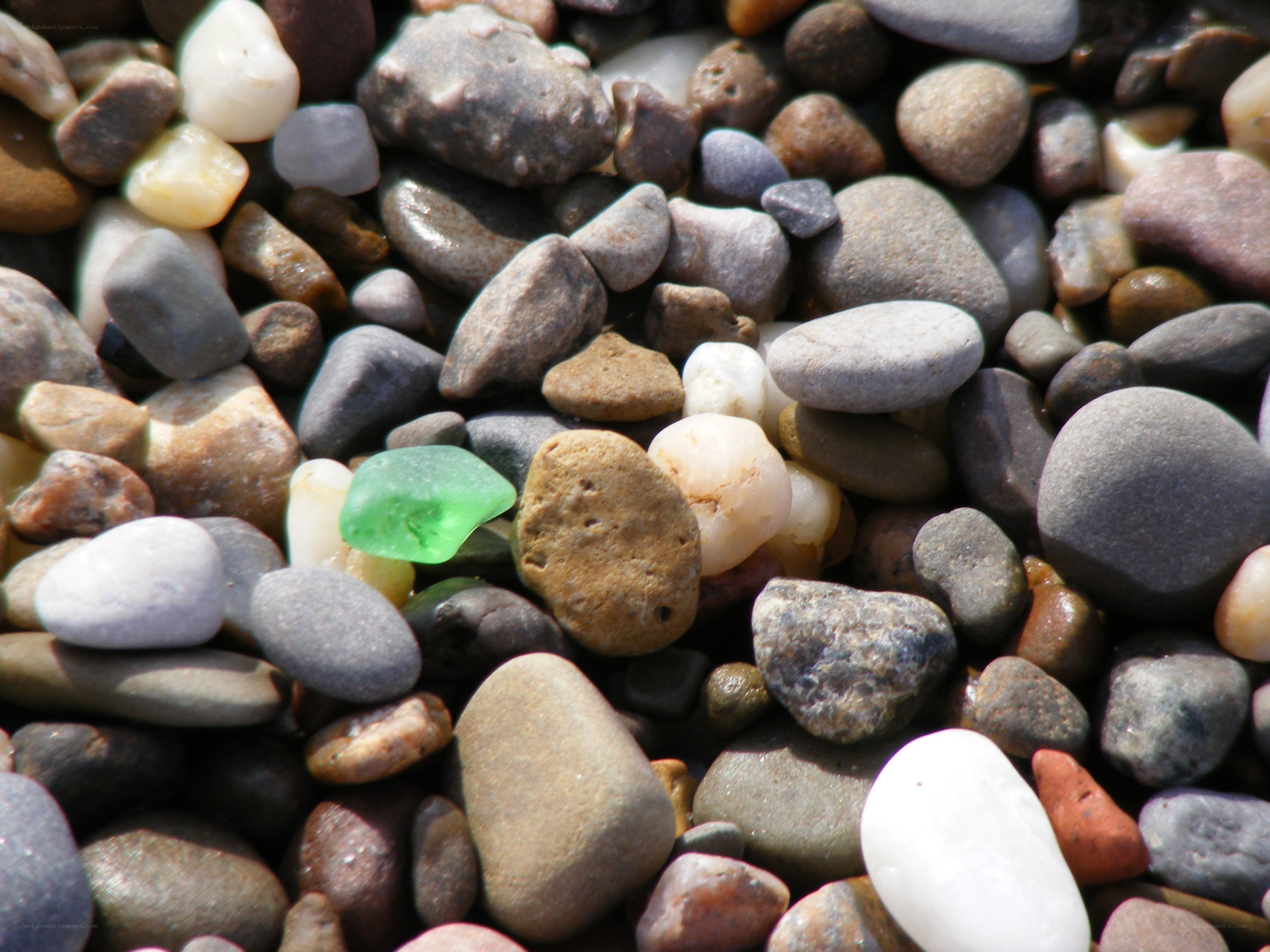 green sea glass among pebbles