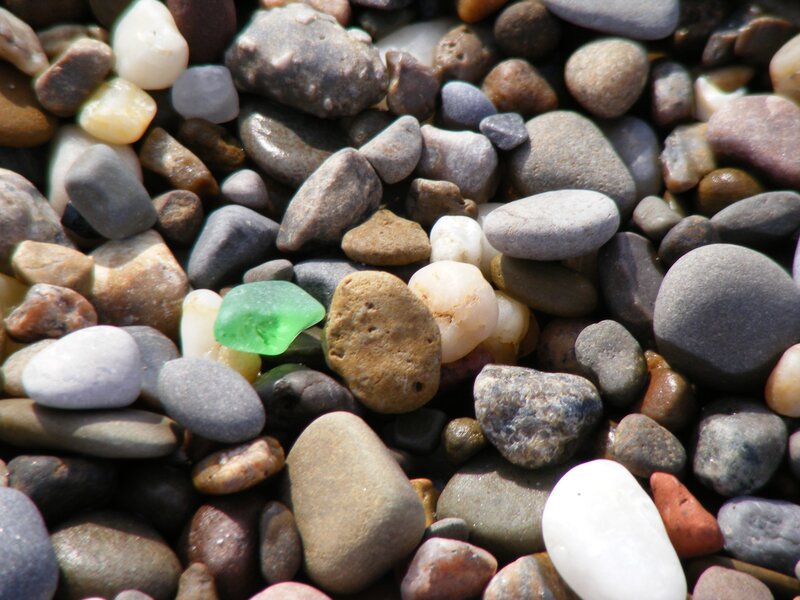 Green Sea Glass Among Pebbles — Gray